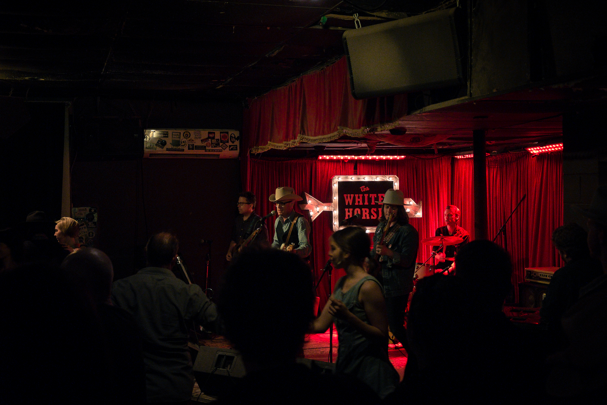 Pessoas dançando ao som de uma banda de música country.